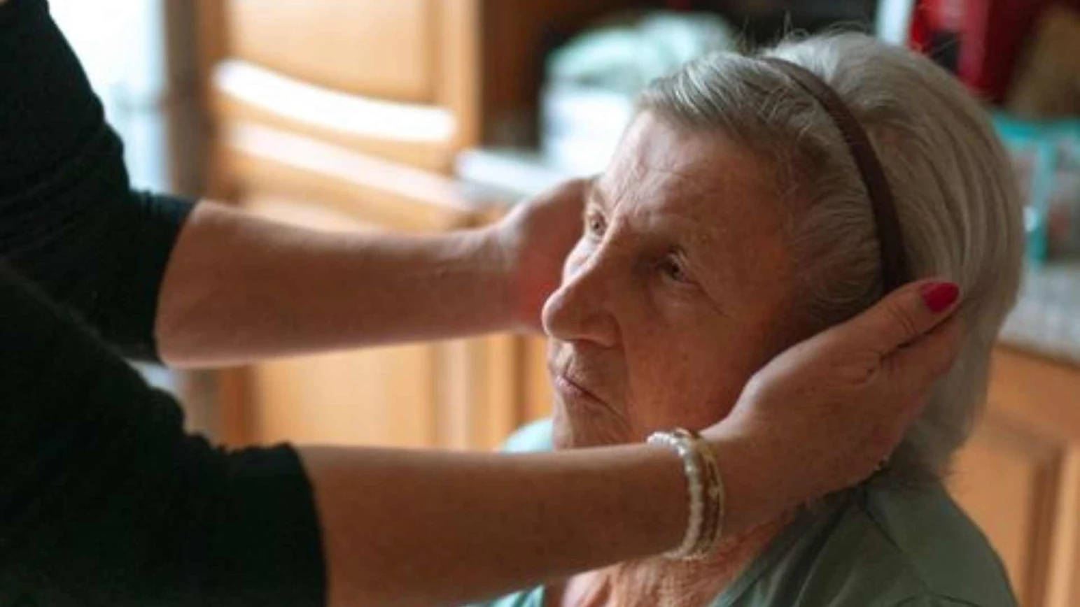 A caregiver helping an elderly client get dressed