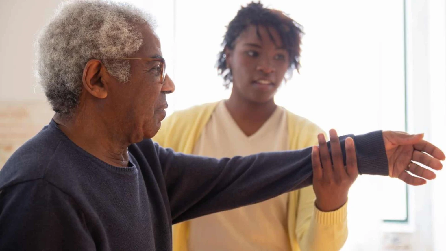 A caregiver helping an elderly patient with mobility